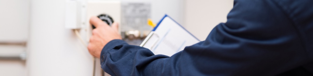 Technician with clipboard adjusting a water heater (page banner)