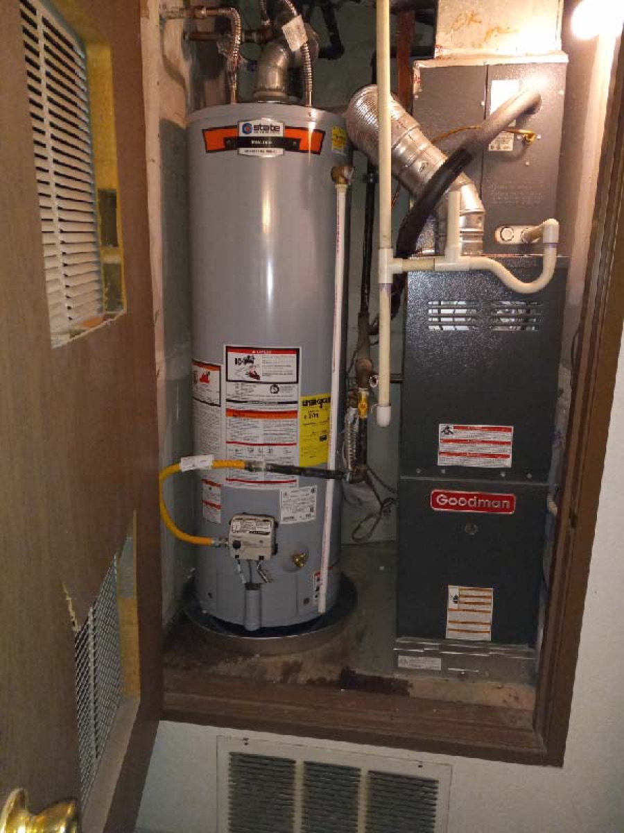 Gas tank water heater installed in a utility closet beside the furnace