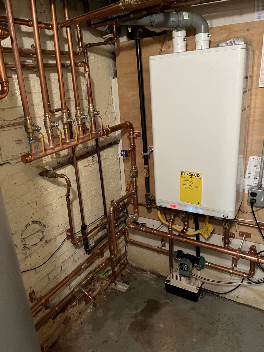 Wall-mounted high-efficiency gas unit with new copper piping in a basement (job photo shown on water heater page)