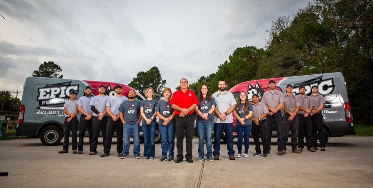 Epic Plumbing staff group photo in front of company vans