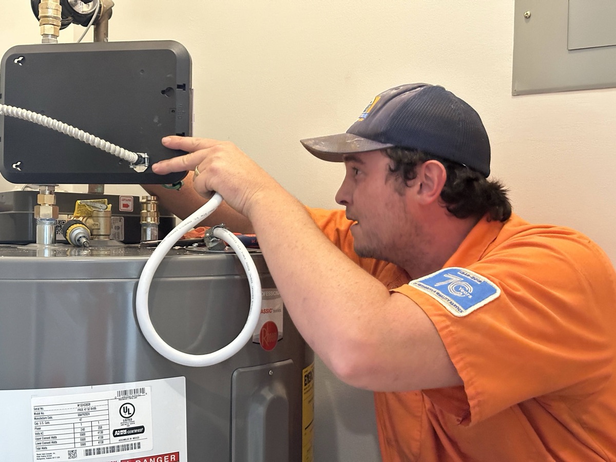Estes technician inspecting a water heater in a utility room