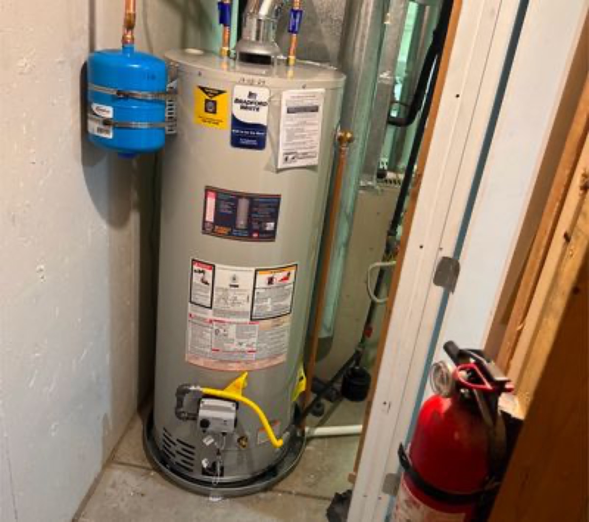 Installed gas tank water heater with expansion tank in a utility closet