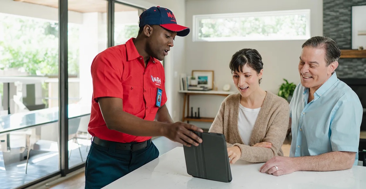 Mr. Rooter professional showing customers service options on a tablet