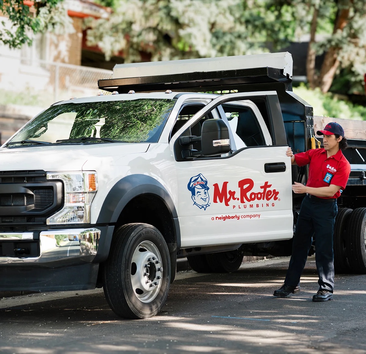 Mr. Rooter truck with technician standing beside it (national brand image)