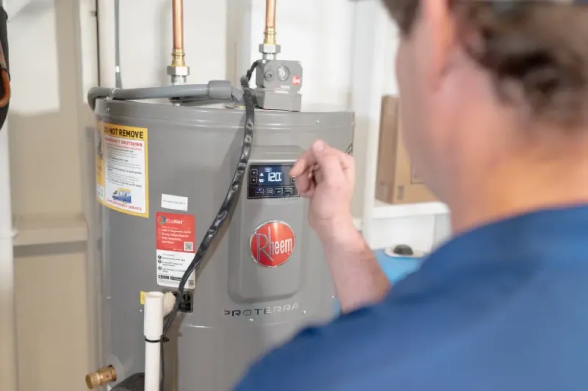MSP technician adjusting controls on a Rheem tank water heater (company marketing photo)