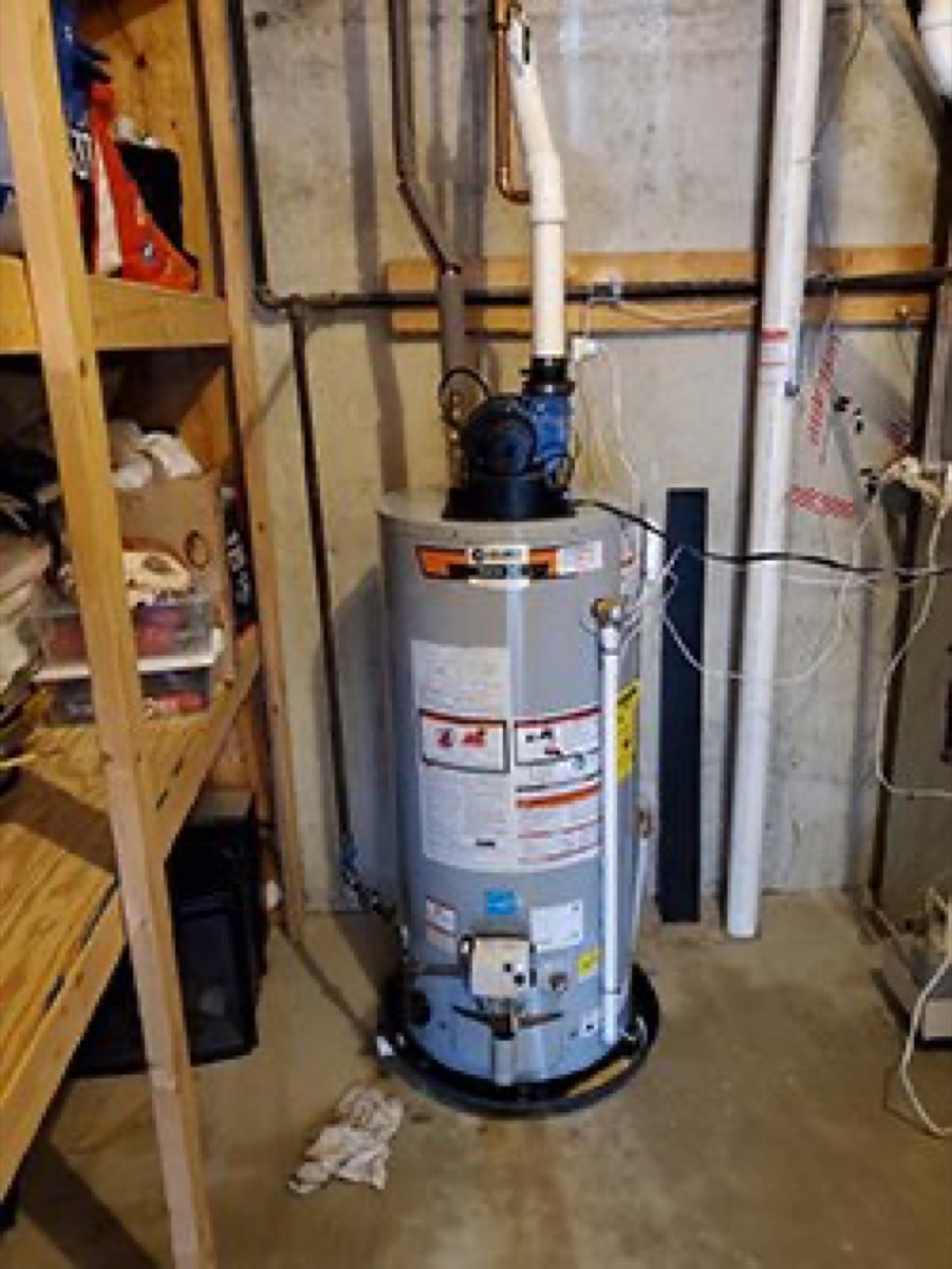 Power-vent gas tank water heater installed in a basement