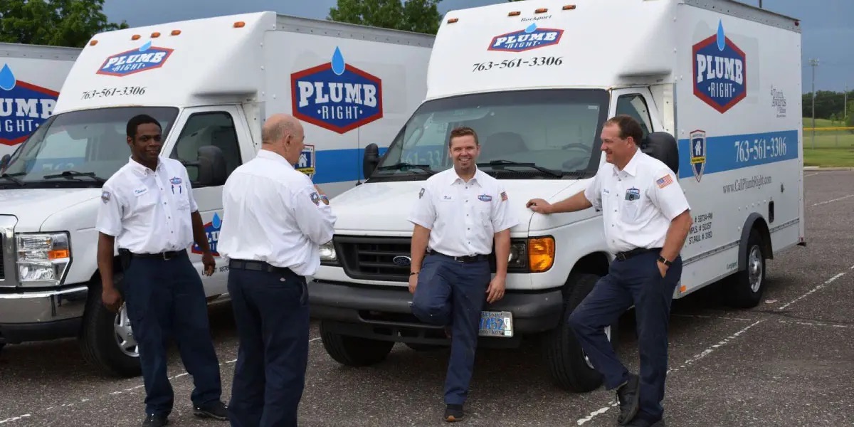 Plumb Right plumbers in uniform beside branded box trucks
