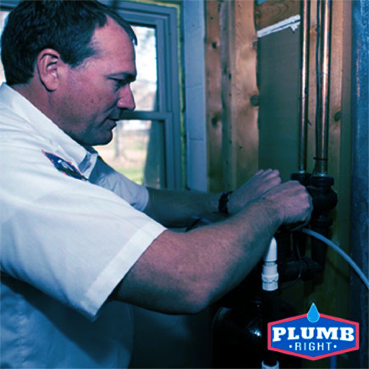 Plumb Right plumber in branded uniform working on plumbing lines