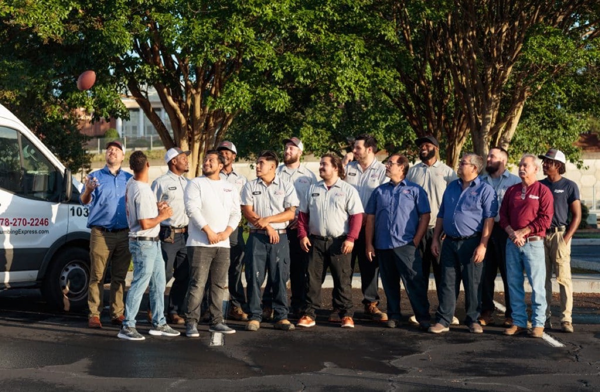 Plumbing Express team group photo beside a service van