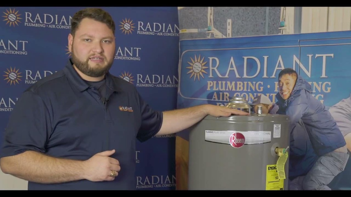Radiant technician with hand on a tank water heater