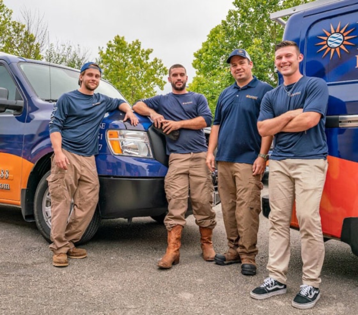 Radiant Plumbing team leaning on work trucks