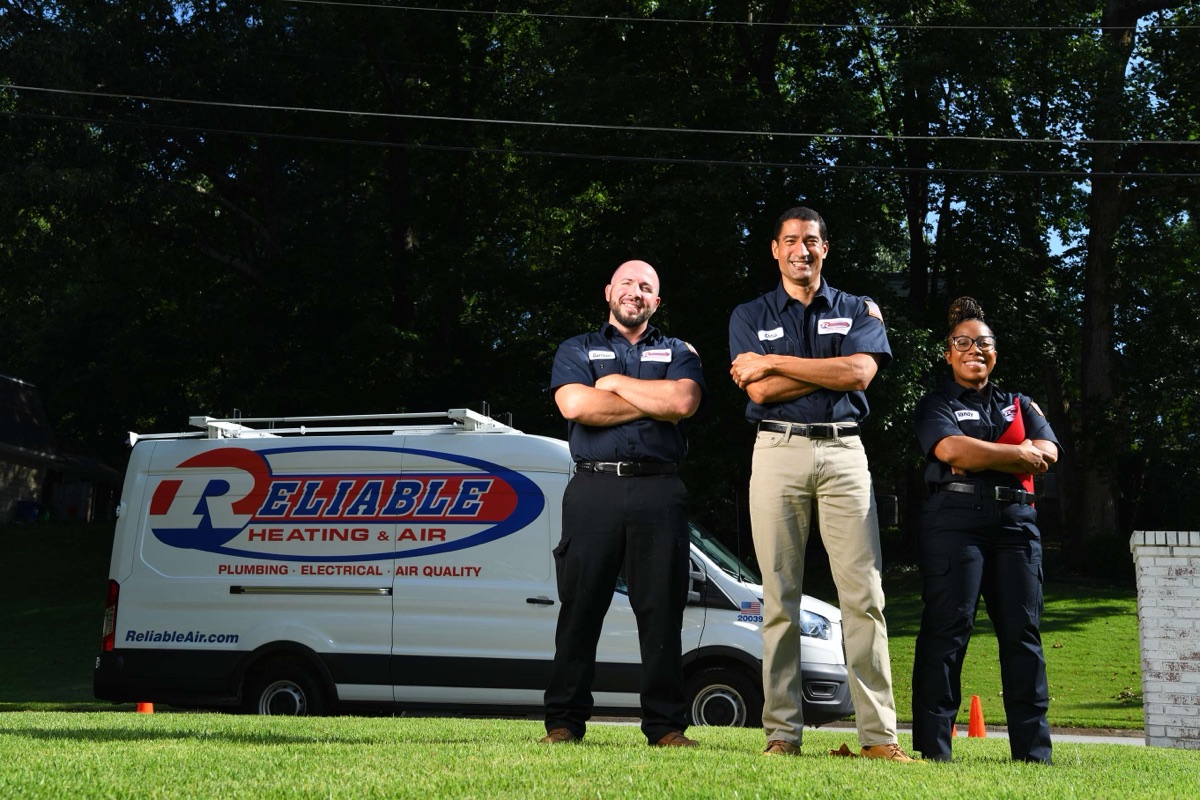 Three Reliable technicians in front of a company van