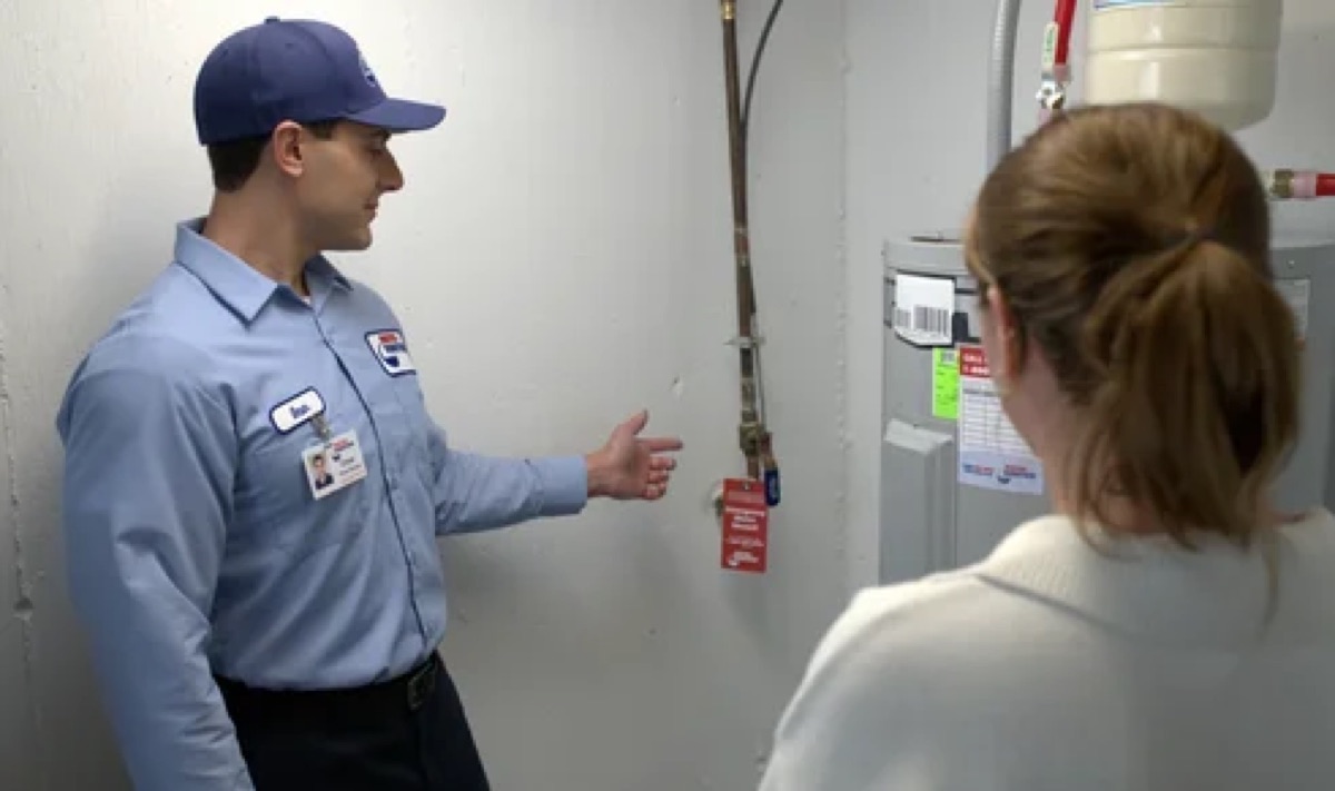 Roto-Rooter technician explaining a water heater to a homeowner