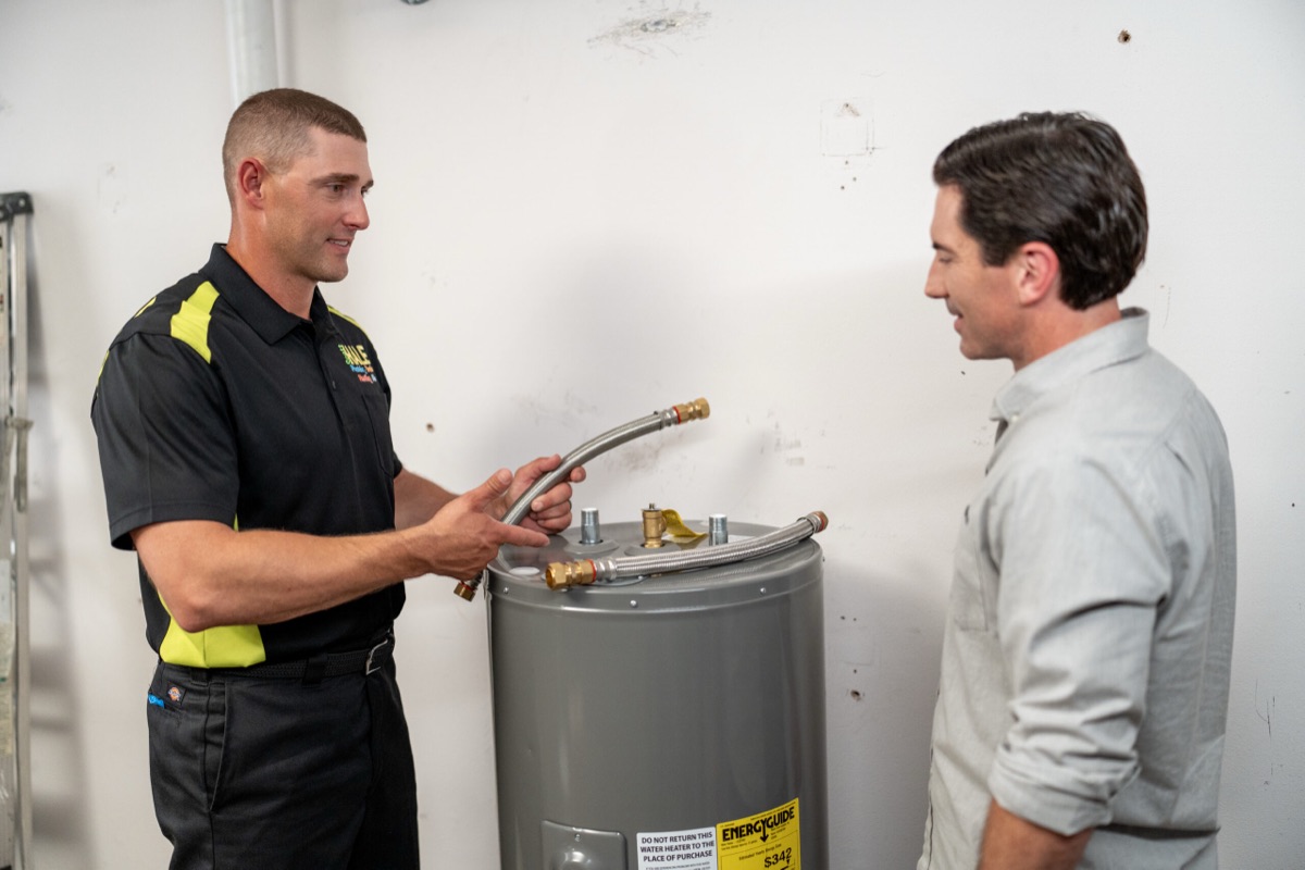 Scott Hale plumber installing a water heater with a customer (site alt text)