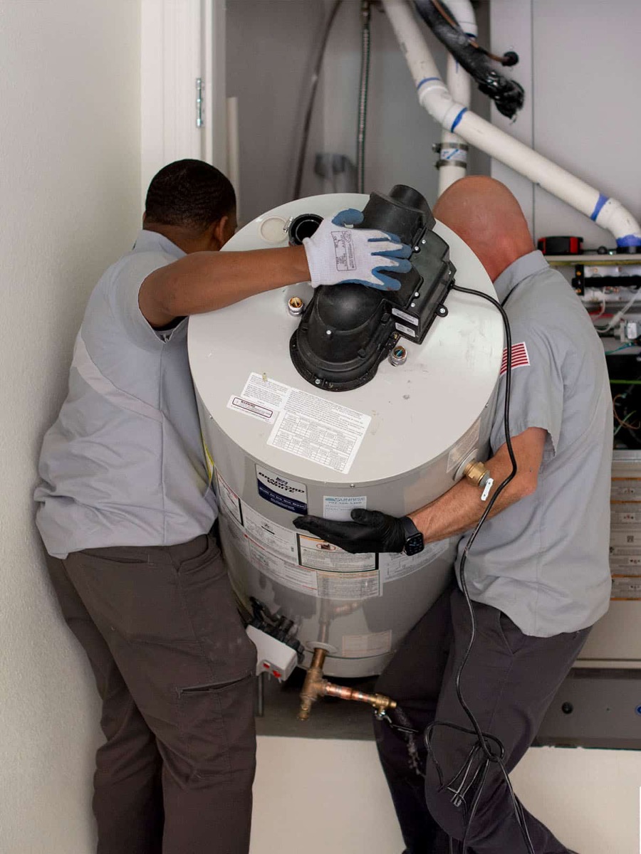Two Sunrise plumbers installing a water heater tank