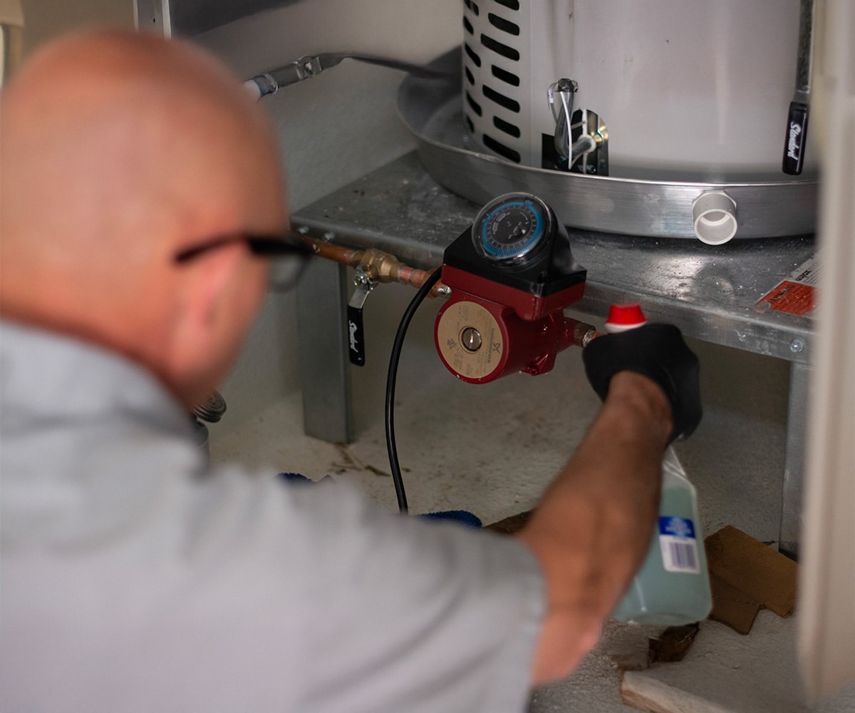 Sunrise tech cleaning under a heater tank