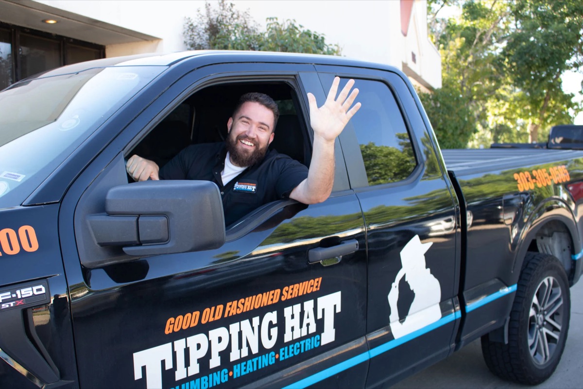 Tipping Hat technician waving from a branded service truck