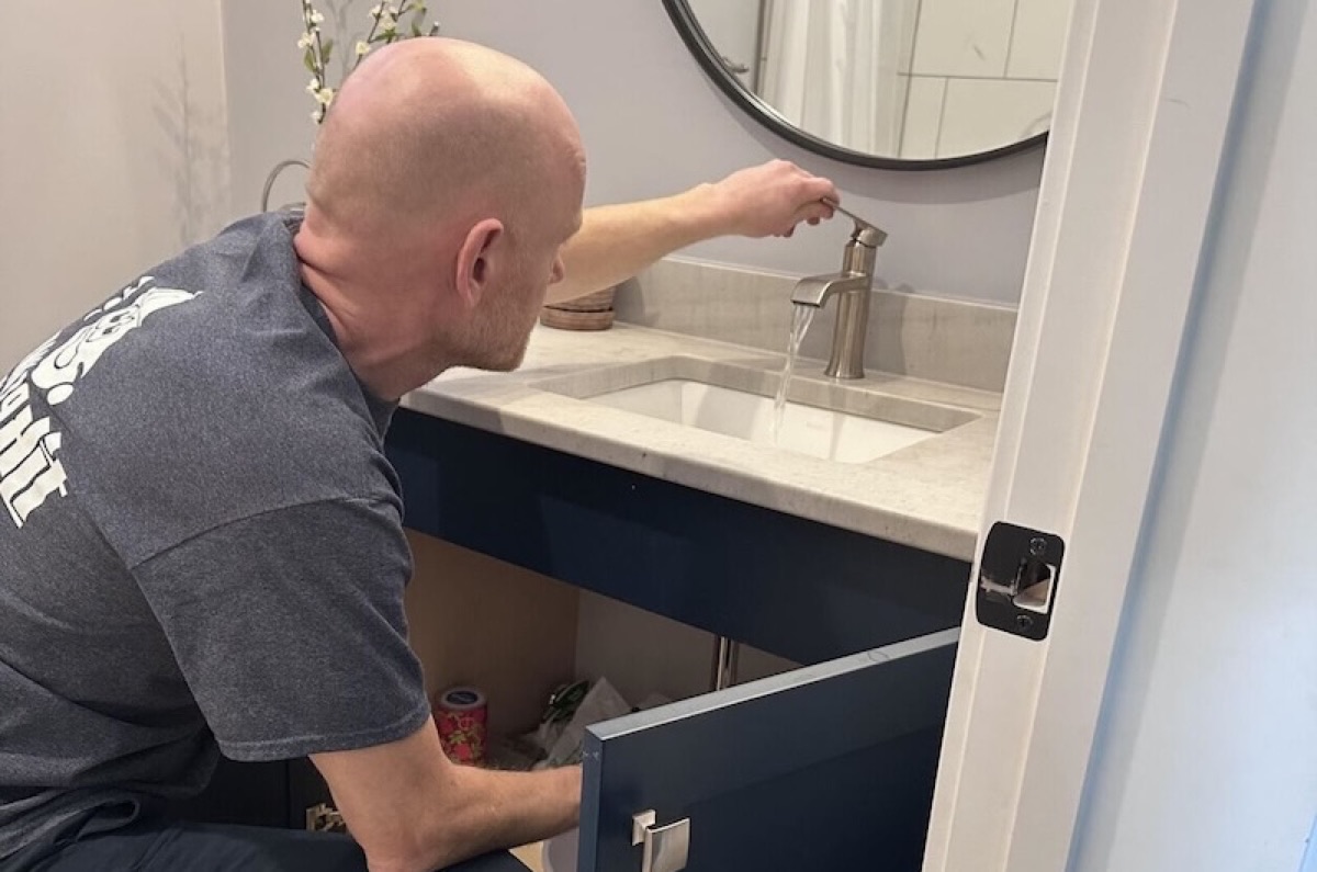 TJK plumber working on a bathroom vanity faucet