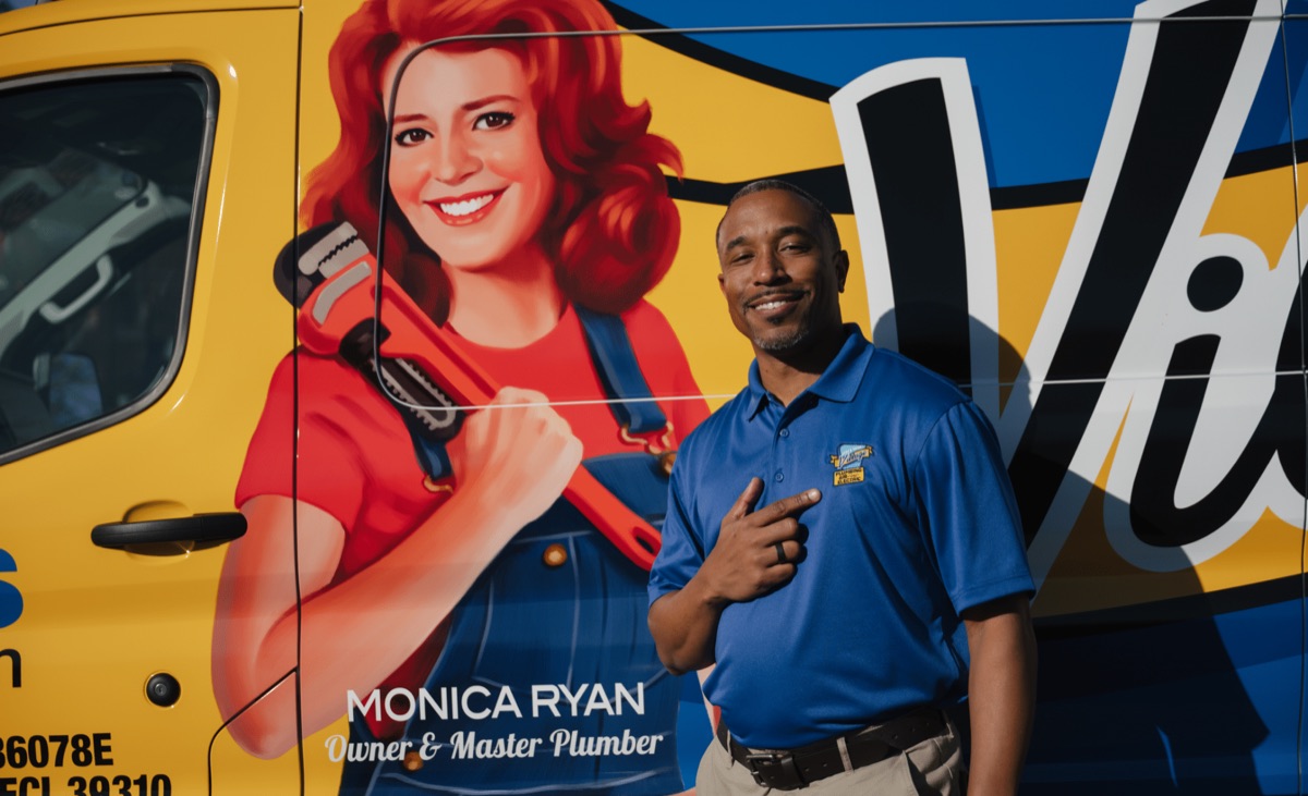 Village technician standing beside a company service van