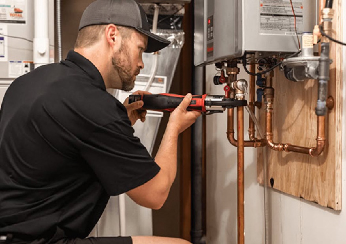 Technician installing a wall-mounted tankless water heater