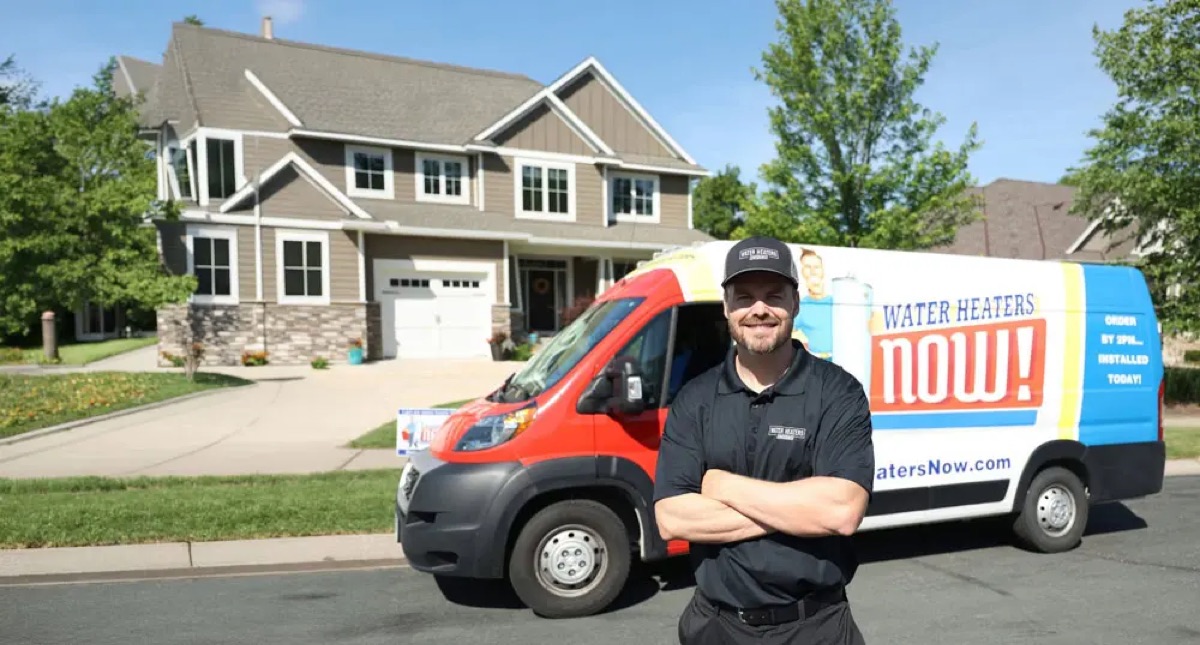 Water Heaters Now team member standing beside company van