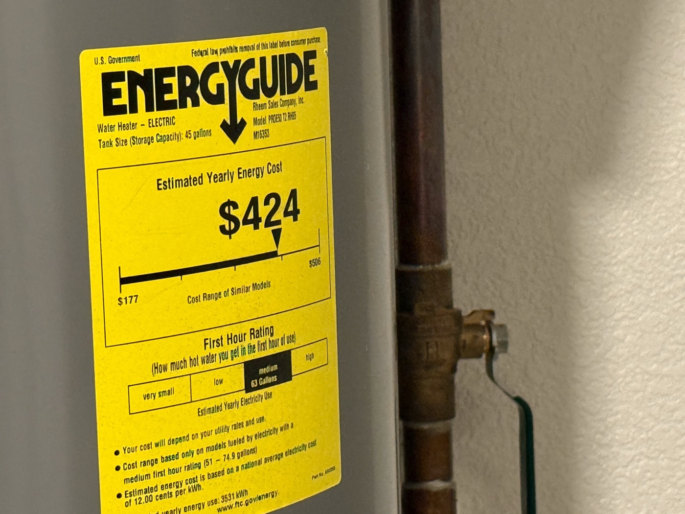 Real photograph of a yellow EnergyGuide label on an electric water heater