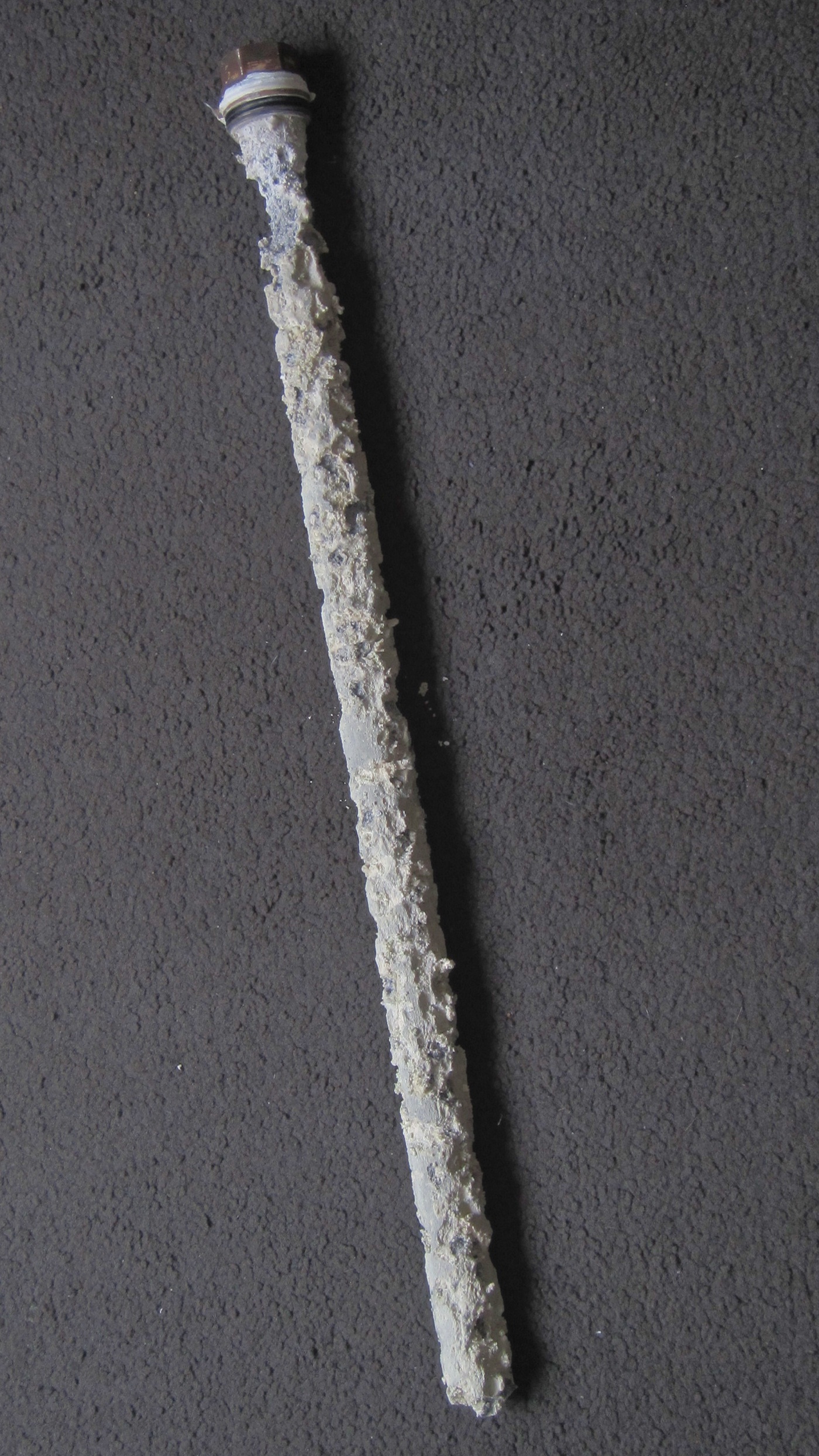 Corroded, crusted magnesium sacrificial anode rod removed from a hot water tank