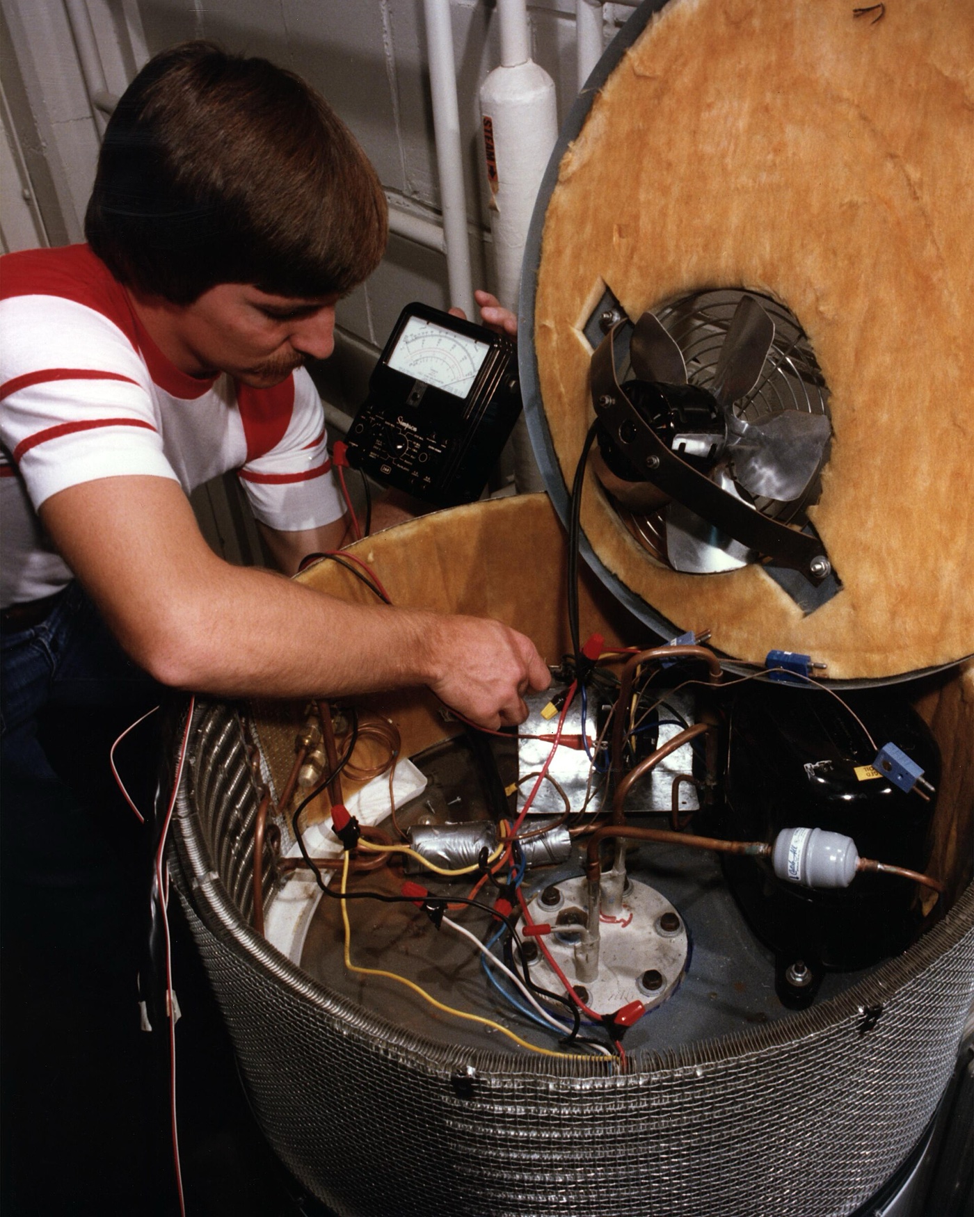 Heat pump water heater with its top-mounted compressor unit exposed during service