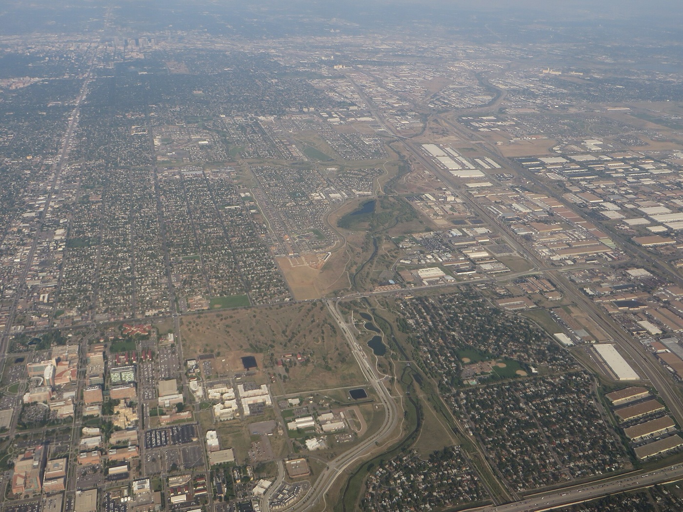 Aerial view over Aurora, Colorado showing a grid of residential neighborhoods, highways and commercial areas