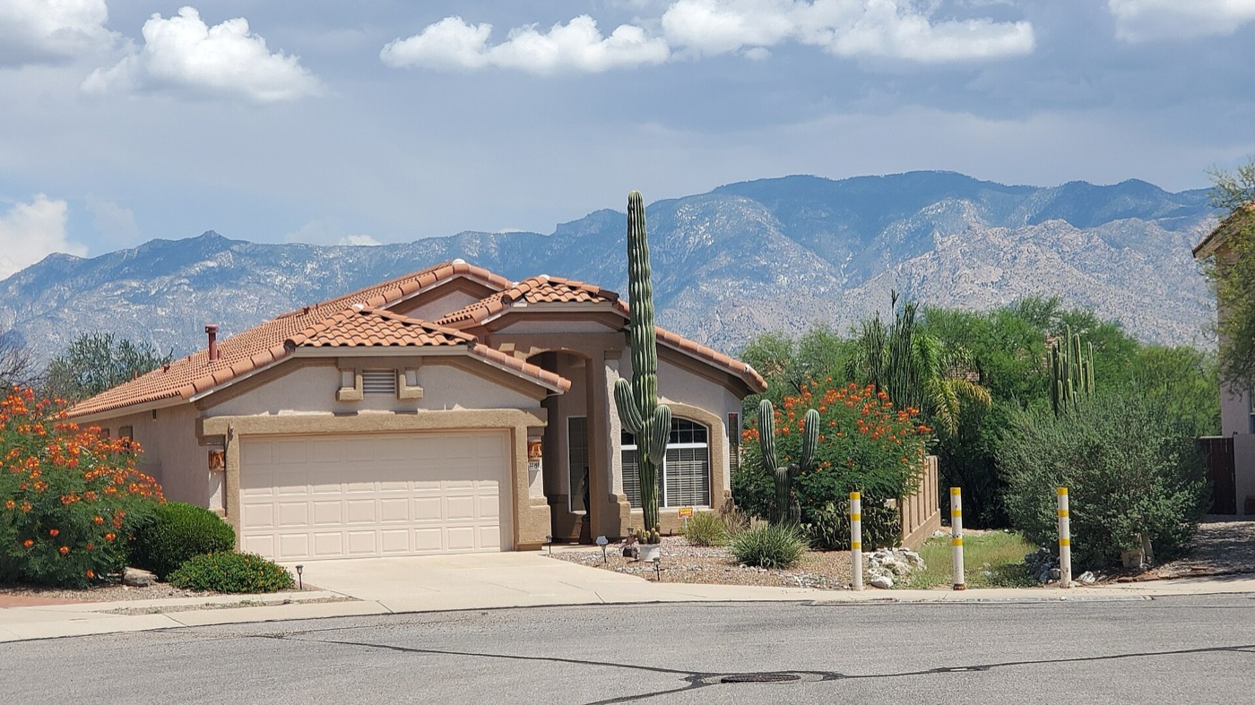 A single-story desert home in Oro Valley with the Santa Catalina Mountains behind it, August 2023