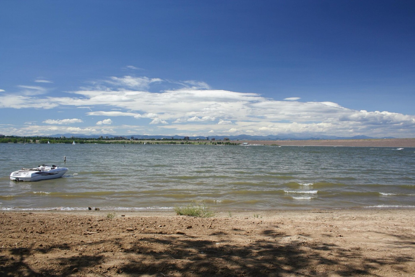 Sandy shore and blue water of Cherry Creek Reservoir under a wide sky