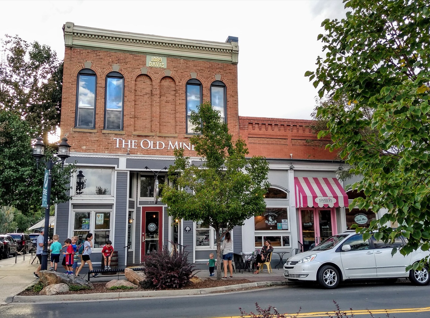 Two-story 1889 red-brick commercial building with striped awnings in historic downtown Erie