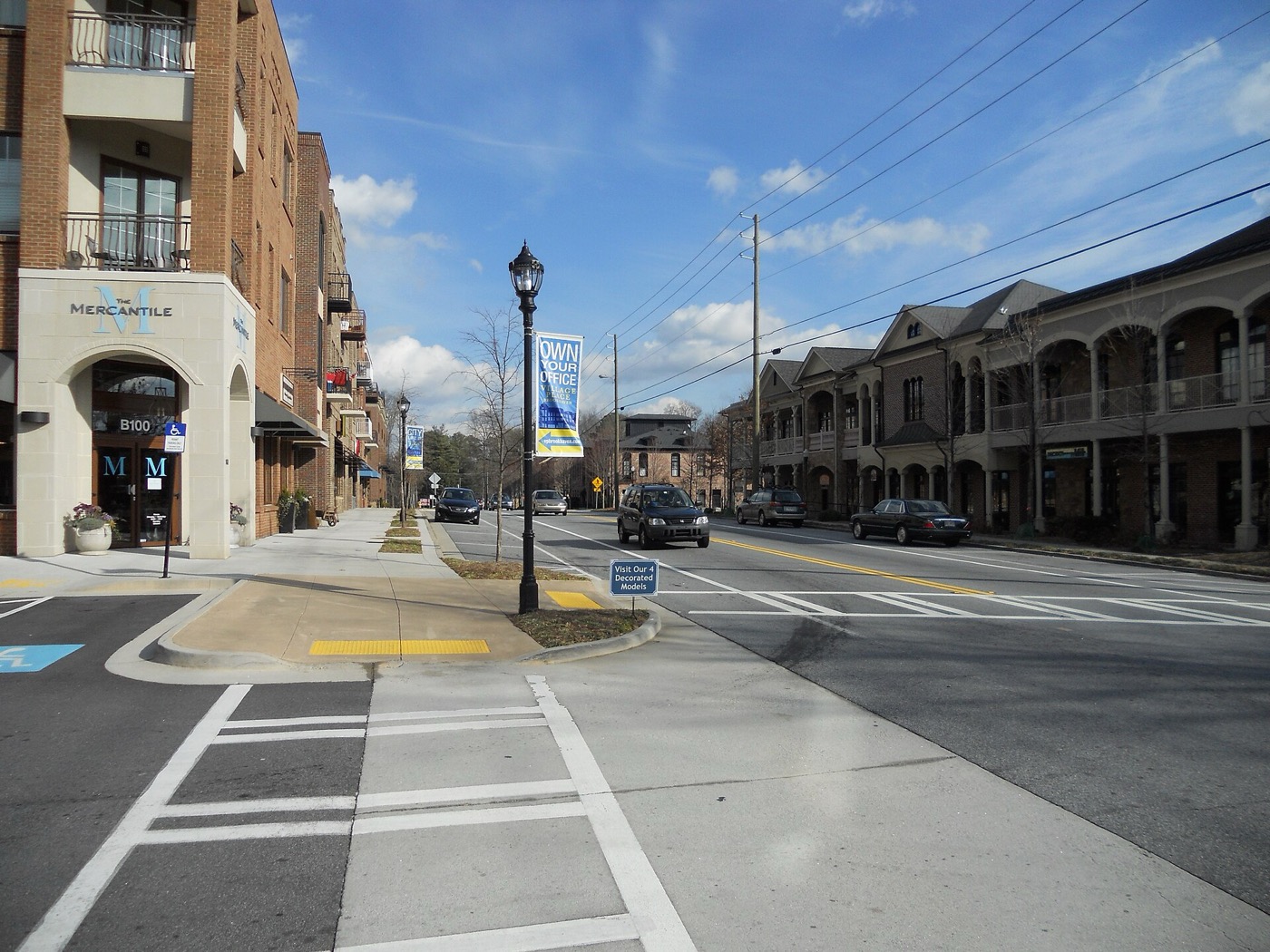 Street and crosswalk lined with mixed-use buildings in Brookhaven Village, Georgia