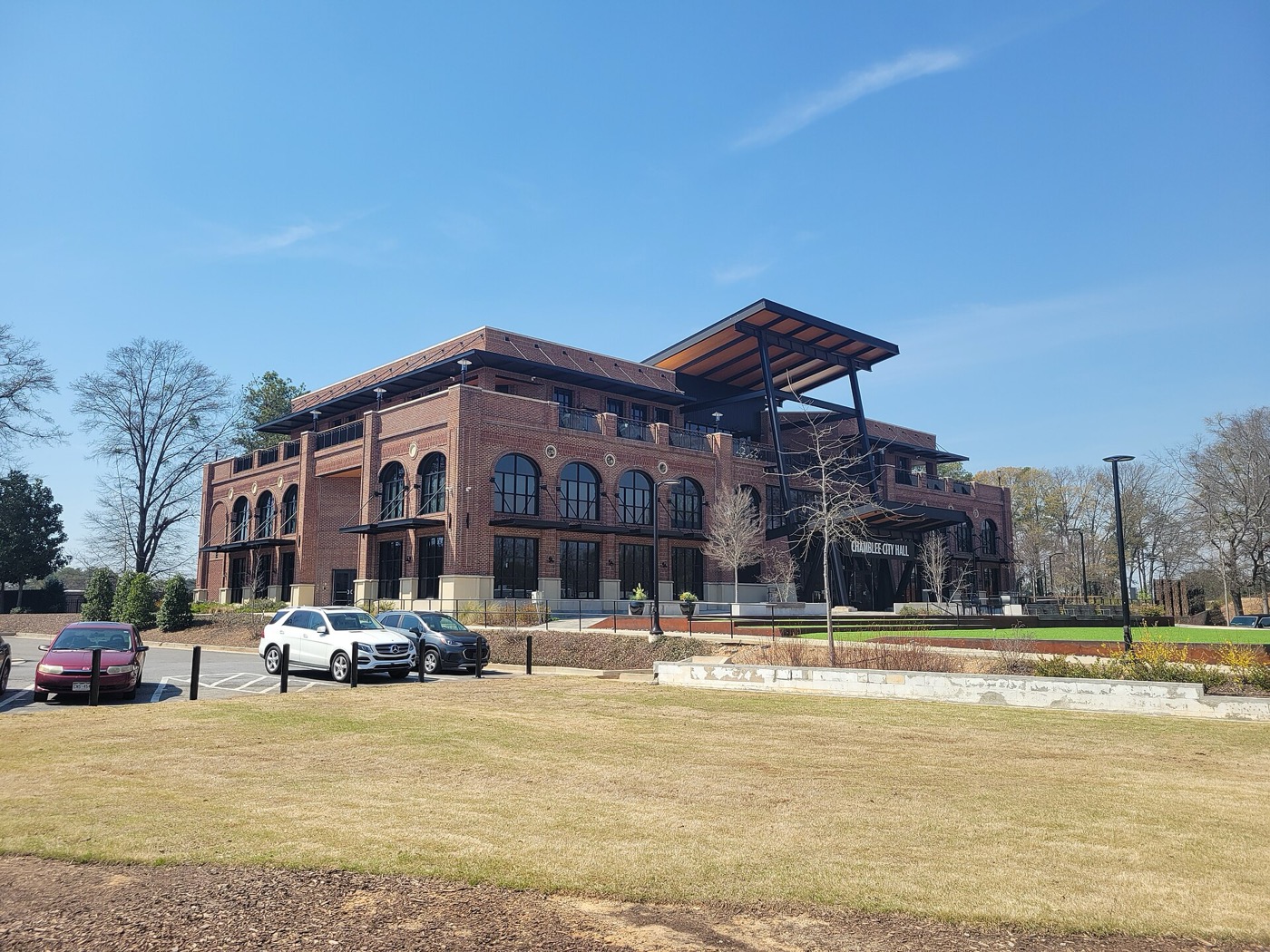 Brick Chamblee City Hall with arched windows and a lawn in front