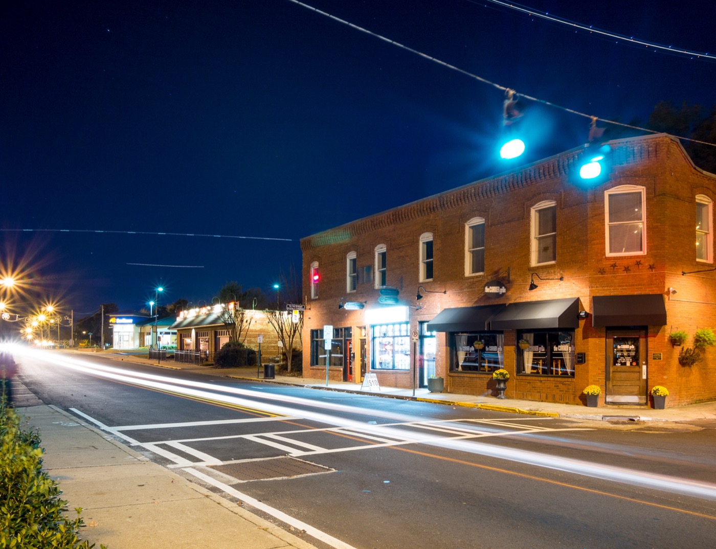 Two-story brick commercial building at a downtown College Park intersection at night
