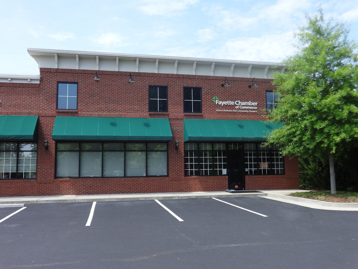 Brick building of the Fayette Chamber of Commerce with green awnings in Fayetteville, Georgia