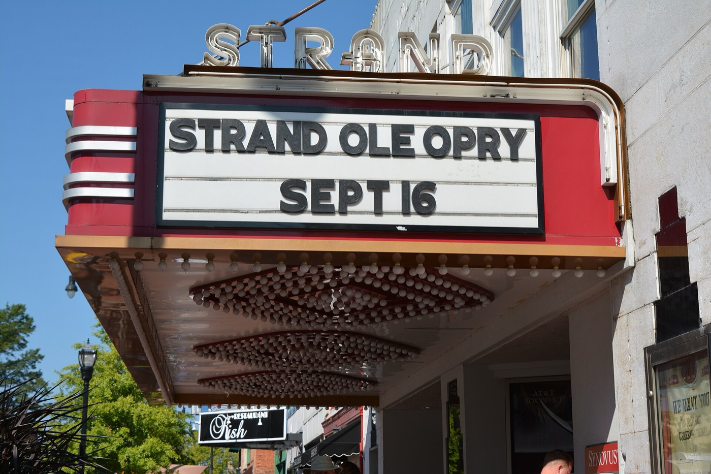 Red and white marquee of the Strand Theatre on the Marietta Square under a clear sky
