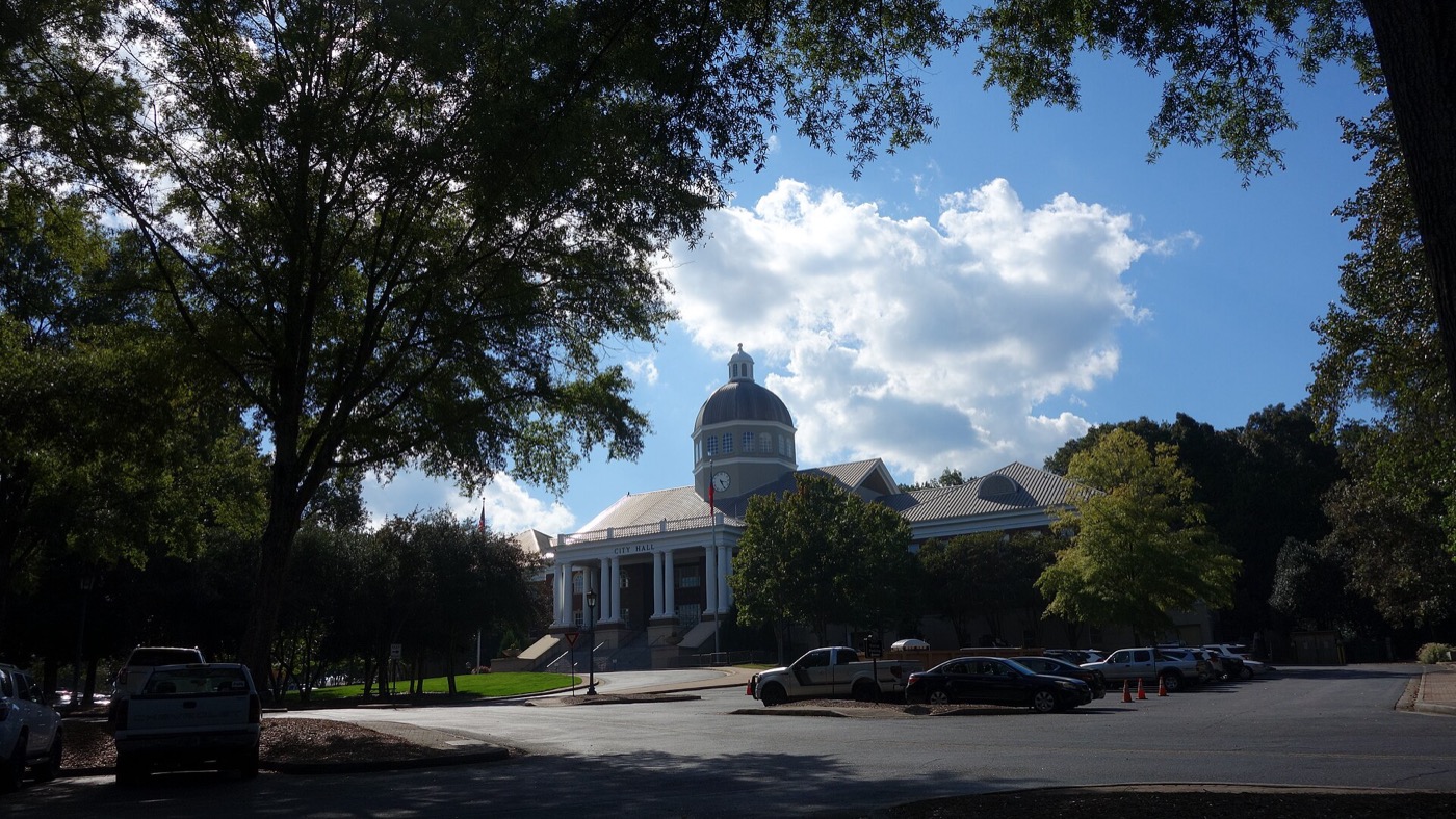 Domed Roswell City Hall seen through shade trees on a sunny day