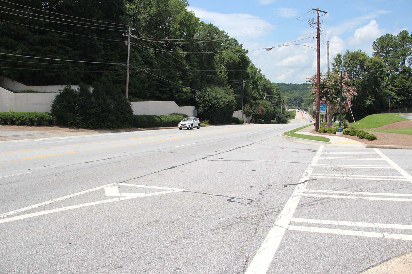 Roswell Road through Sandy Springs, Georgia, with traffic lanes and roadside buildings on a summer day