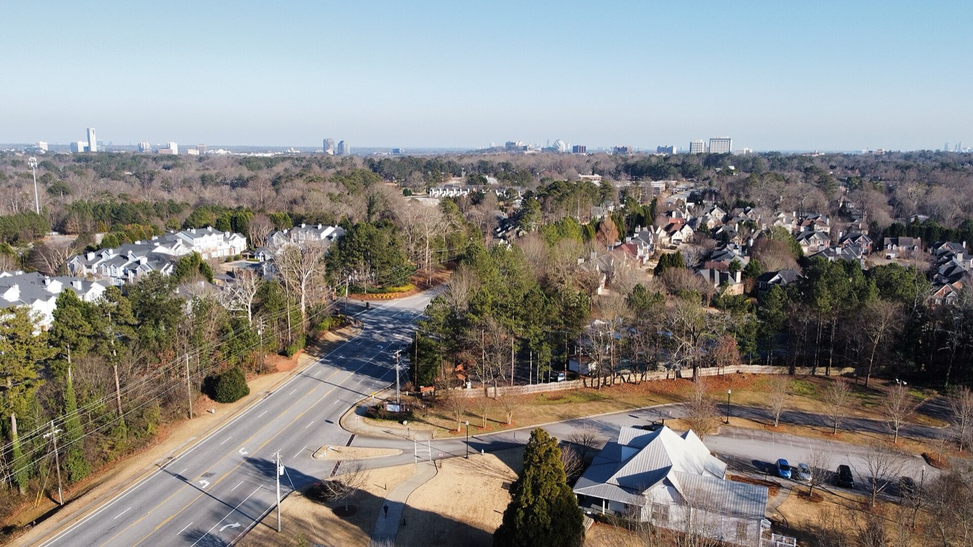 Aerial view over Smyrna neighborhoods and a road, with the Atlanta skyline on the horizon