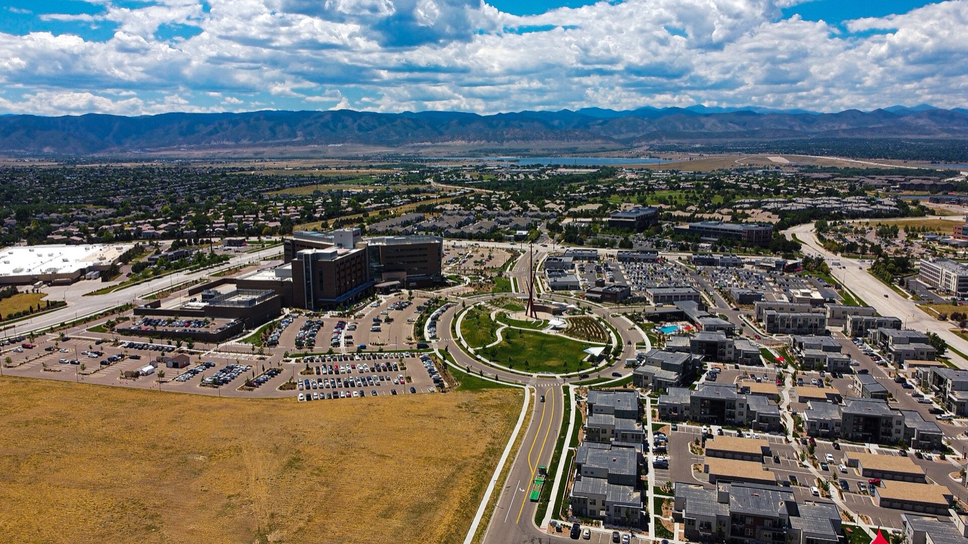 Aerial view of Highlands Ranch homes and town center with the Front Range on the horizon