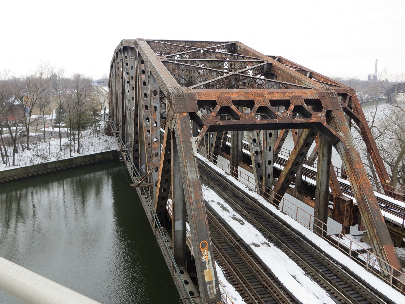 A steel truss railroad bridge over a waterway in Blue Island in winter