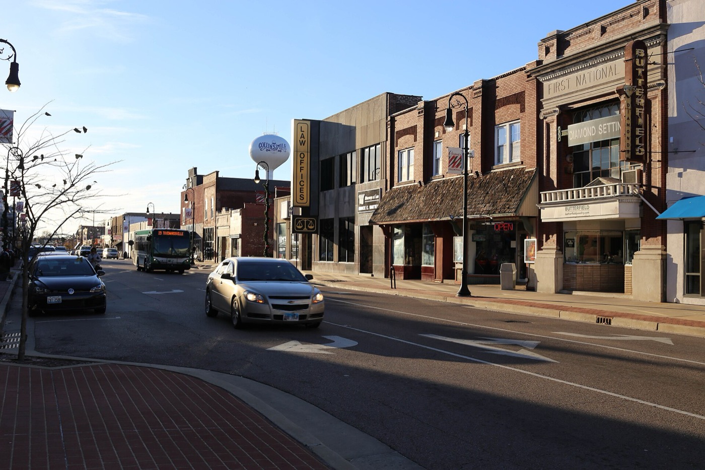 Brick commercial buildings along Main Street in Collinsville, Illinois, with a water tower behind