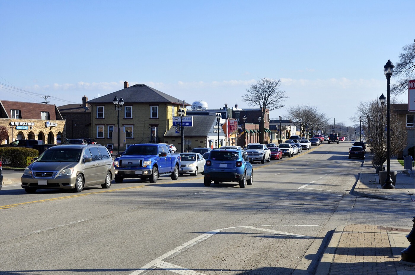 Traffic on a downtown Mundelein street lined with older buildings