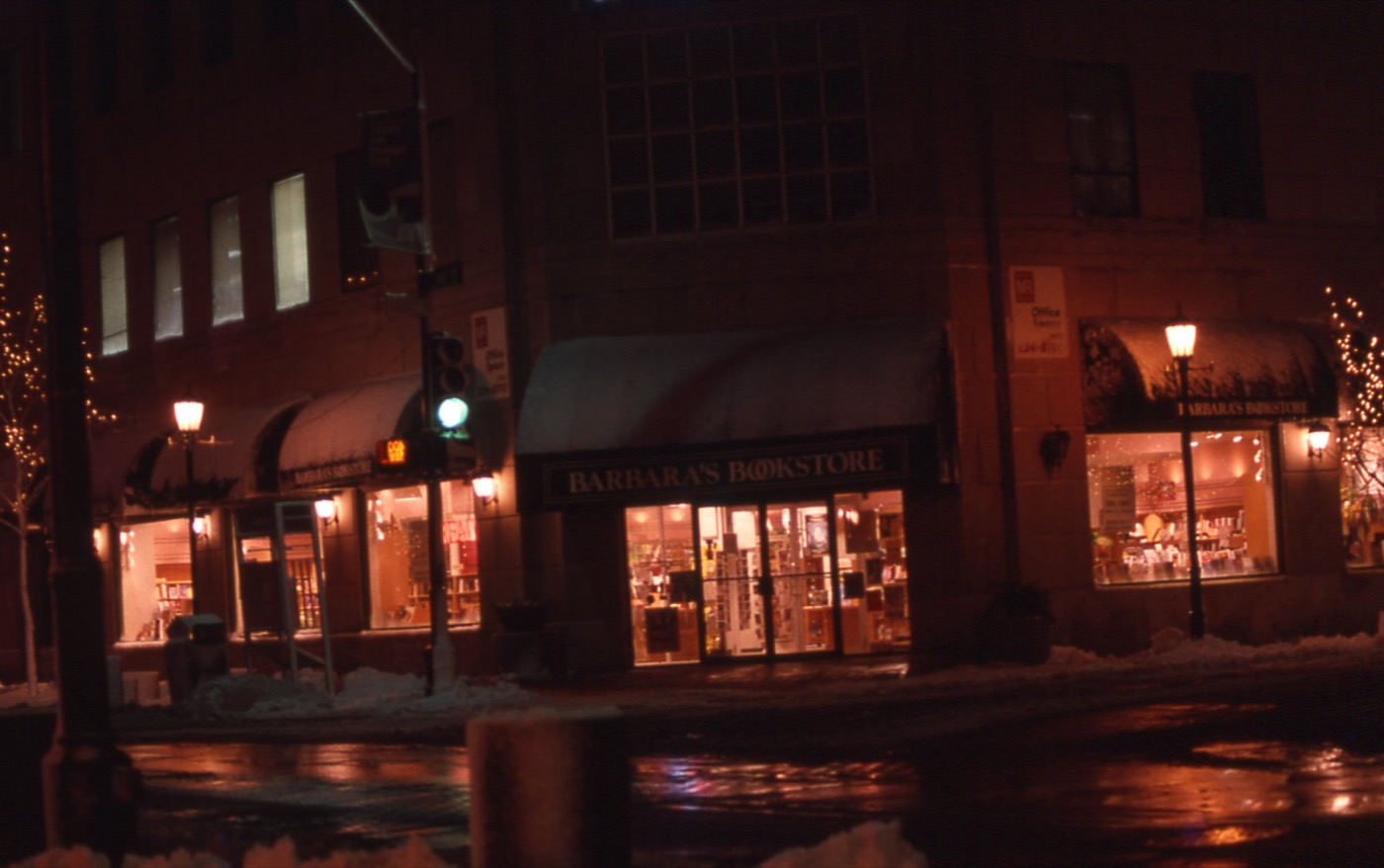 Lit storefronts on Marion Street in downtown Oak Park at night
