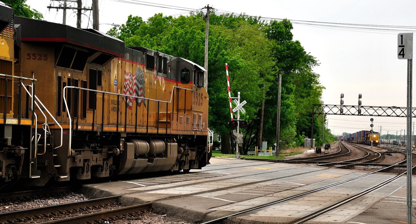 Freight locomotive crossing a street at a rail crossing in West Chicago