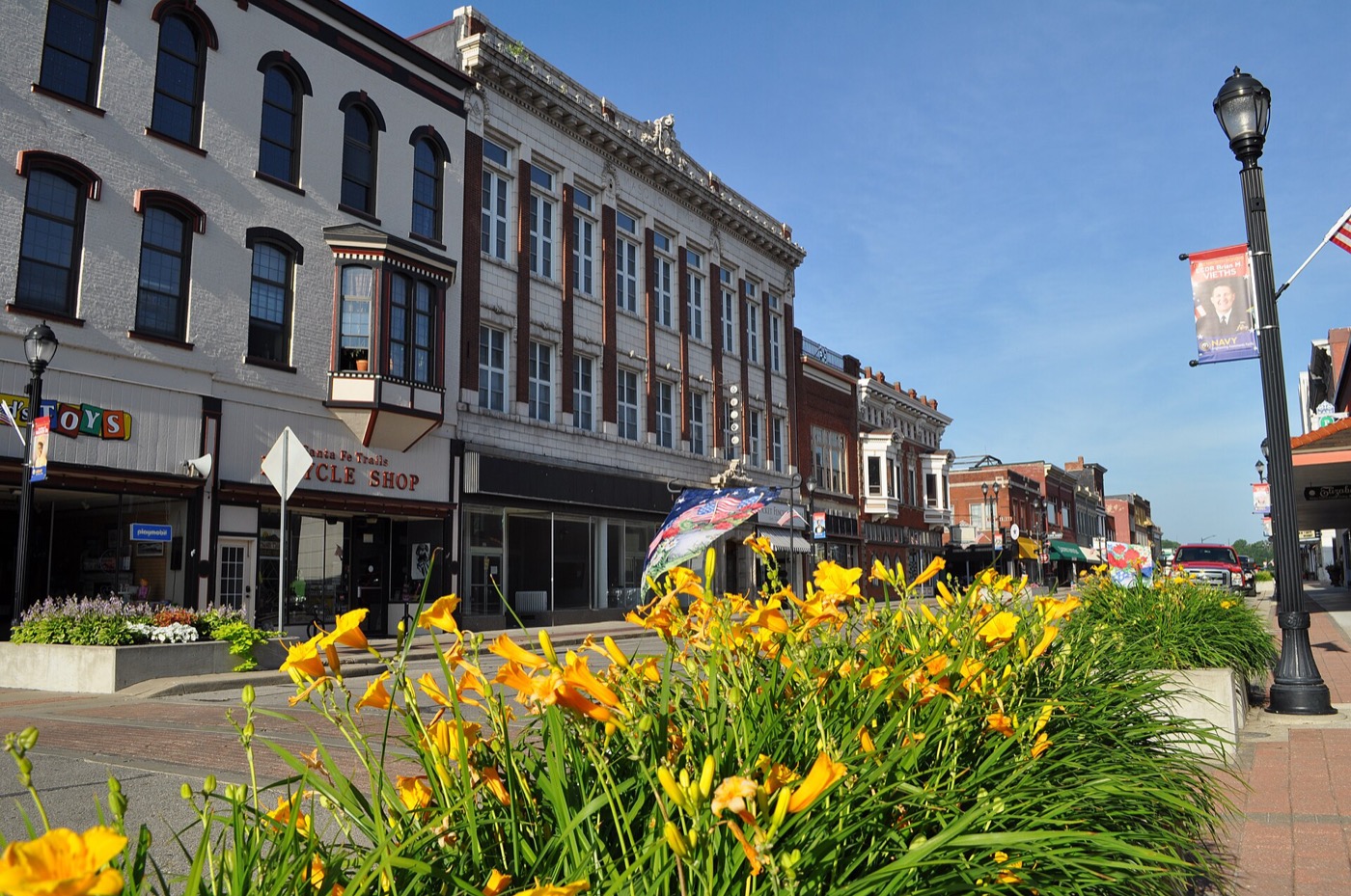 Day lilies along Delaware Street with the historic Masonic Building in downtown Leavenworth, Kansas