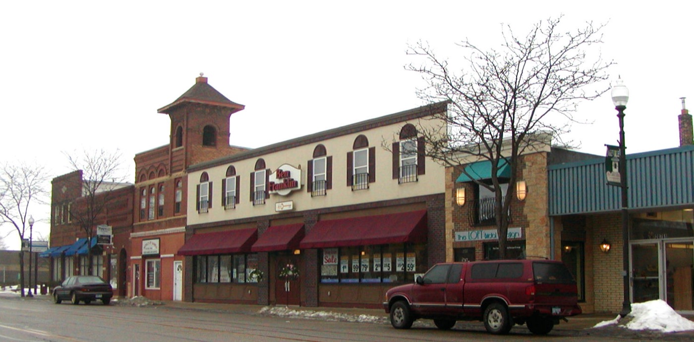 Brick commercial buildings with awnings on a downtown Lakeville street in winter