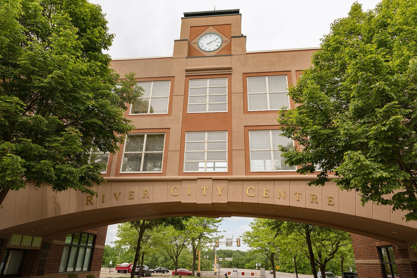 River City Centre building with clock tower and arched skyway over a street in downtown Shakopee