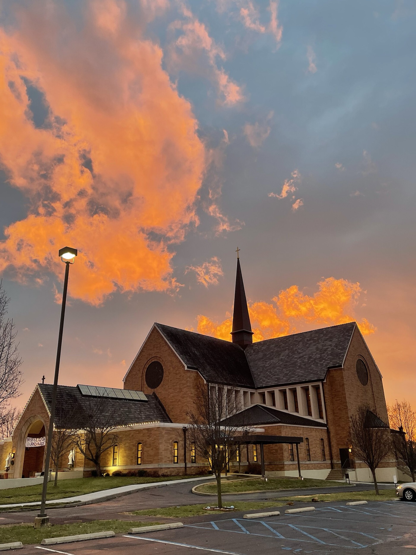 Immaculate Conception Church in Dardenne Prairie, Missouri, against a sunset sky